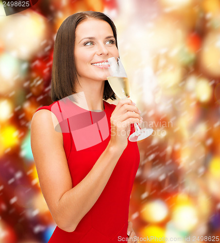 Image of woman in red dress with a glass of champagne