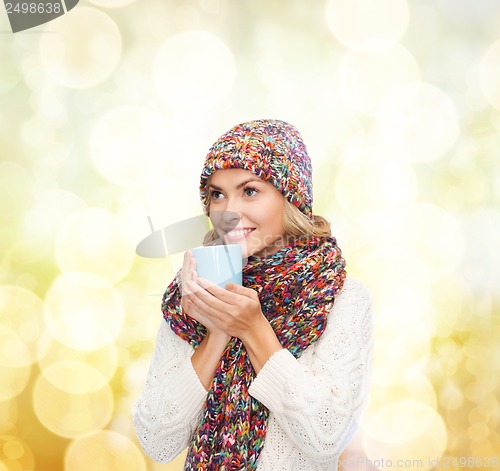 Image of woman in hat with red tea or coffee mug