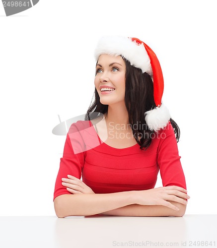 Image of surprised woman in santa helper hat looking up