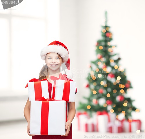 Image of girl in santa helper hat with many gift boxes