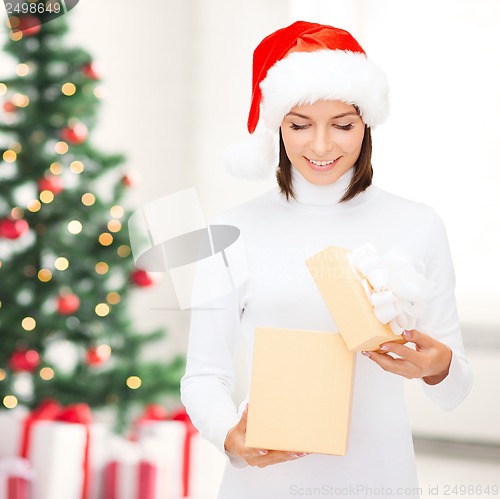 Image of smiling woman in santa helper hat with gift box