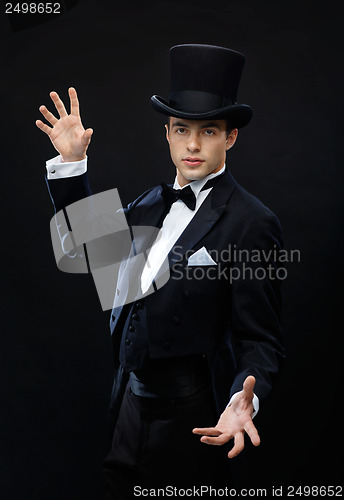 Image of magician in top hat showing trick