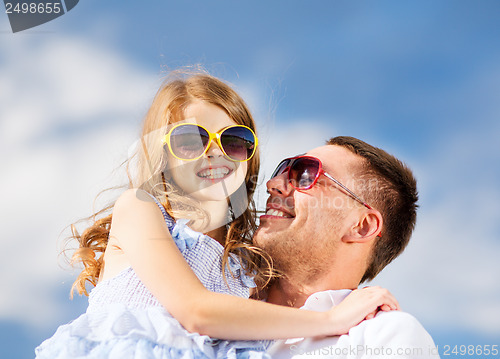 Image of happy father and child in sunglasses over blue sky