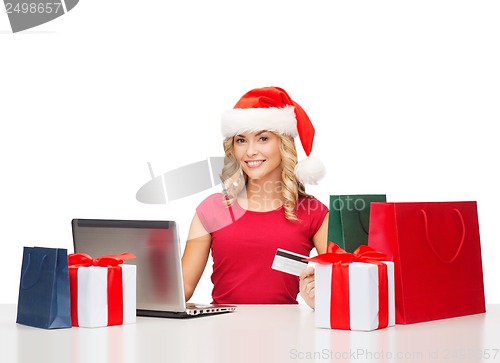 Image of woman with gifts, laptop computer and credit card