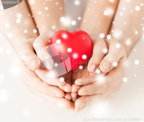 Image of woman and man hands with heart