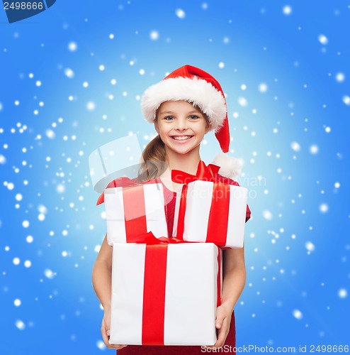 Image of girl in santa helper hat with many gift boxes
