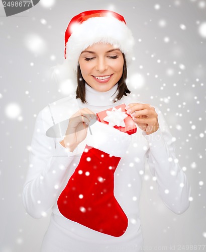 Image of woman in santa hat with gift box and stocking