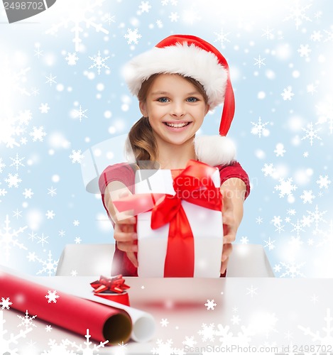 Image of smiling girl in santa helper hat with gift box