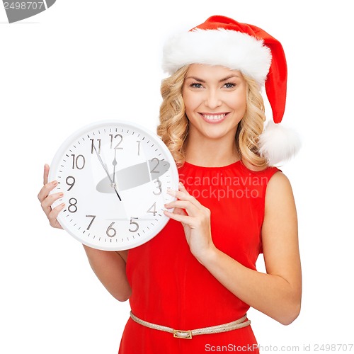 Image of woman in santa helper hat with clock showing 12