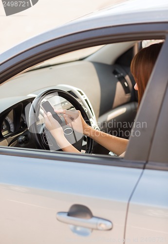 Image of woman using phone while driving the car