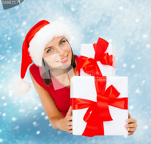 Image of smiling woman in santa helper hat with gift boxes