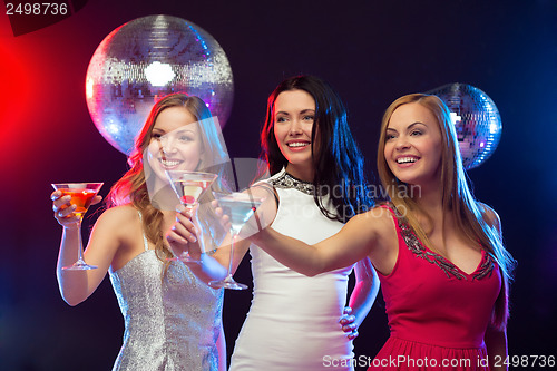 Image of three smiling women with cocktails and disco ball