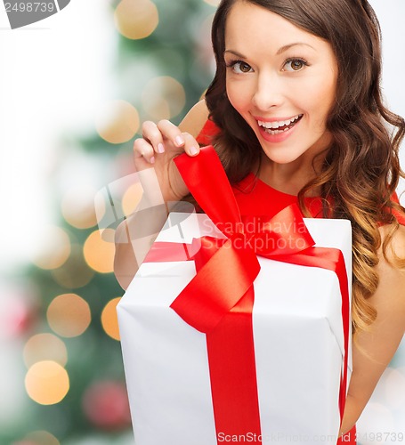 Image of smiling woman in red dress with gift box