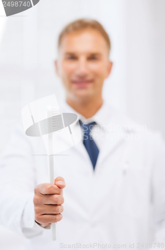 Image of dentist with toothbrush in hospital