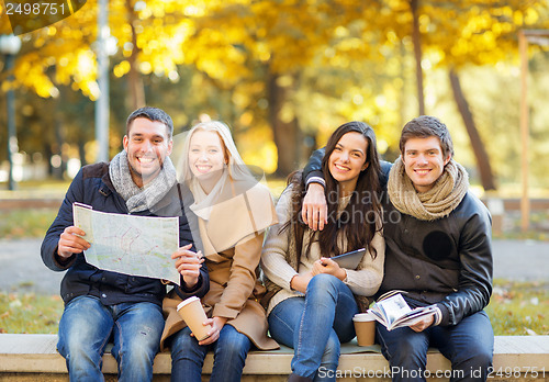 Image of couples with tourist map in autumn park