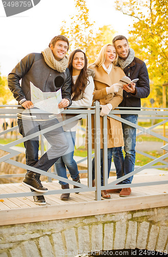 Image of couples with tourist map in autumn park