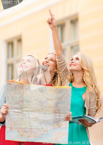 Image of beautiful women with tourist map in the city