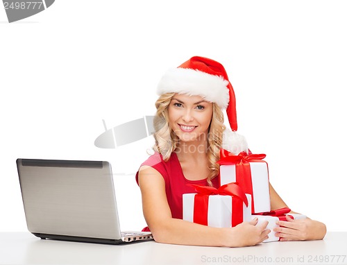 Image of woman with gift boxes and laptop computer