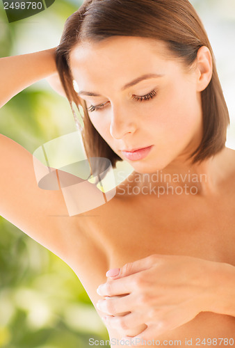 Image of woman checking breast for signs of cancer