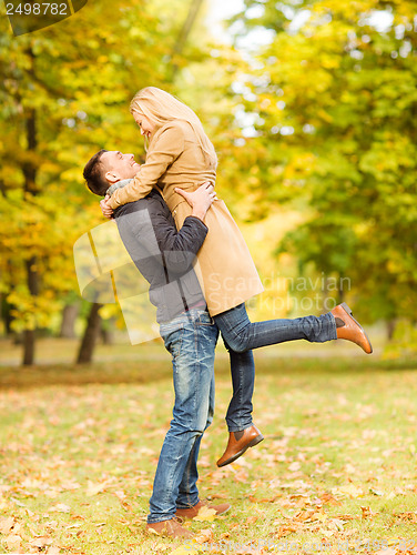 Image of romantic couple playing in the autumn park