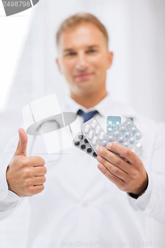 Image of male doctor with packs of pills