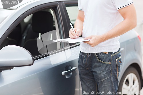 Image of man with car documents