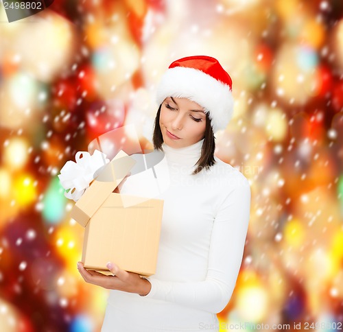Image of suspicious woman in santa helper hat with gift box