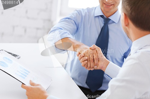 Image of businessmen shaking hands in office