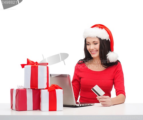 Image of woman with gifts, laptop computer and credit card