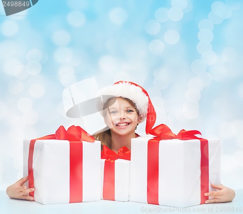 Image of girl in santa helper hat with many gift boxes