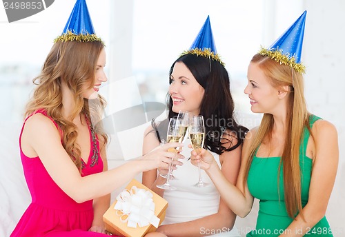 Image of three women wearing hats with champagne glasses