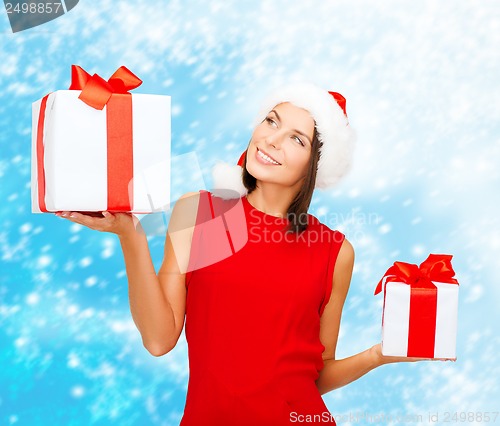 Image of woman in santa helper hat with many gift boxes