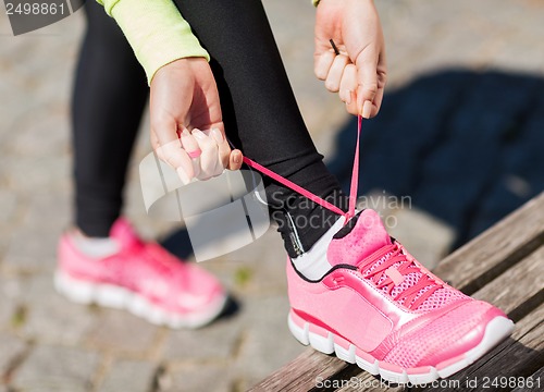 Image of runner woman lacing trainers shoes