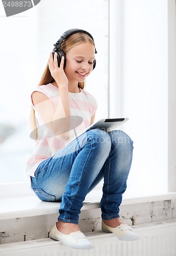 Image of girl with tablet pc and headphones at home