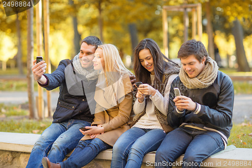 Image of group of friends having fun in autumn park