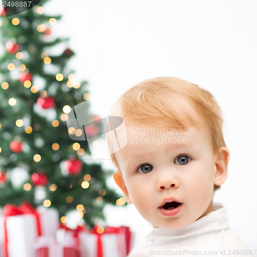 Image of happy little boy with christmas tree and gifts