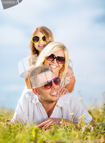 Image of happy family with blue sky and green grass