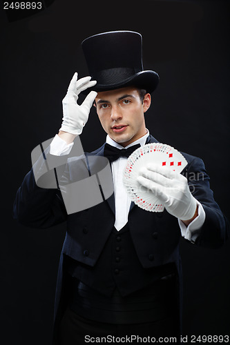 Image of magician showing trick with playing cards