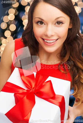 Image of smiling woman in red dress with gift box