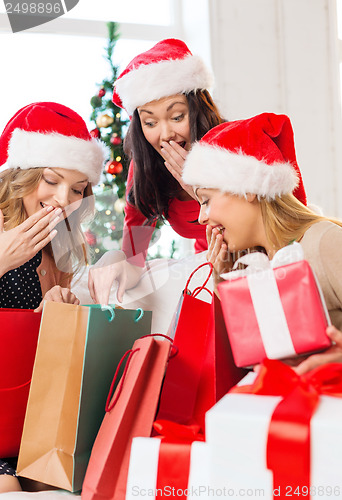 Image of women in santa helper hats with shopping bags