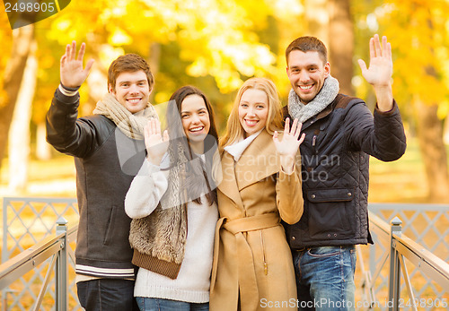 Image of group of friends having fun in autumn park