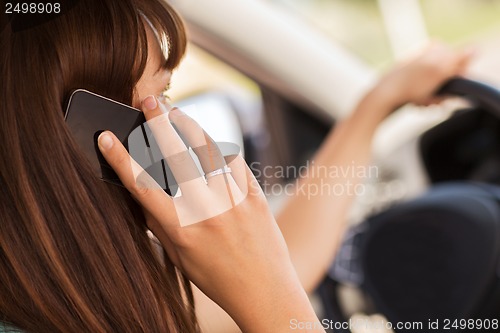 Image of woman using phone while driving the car