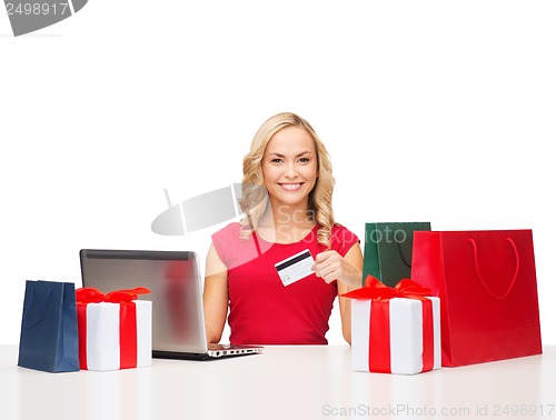 Image of woman with gifts, laptop computer and credit card