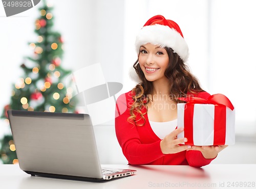 Image of woman with gift box and laptop computer