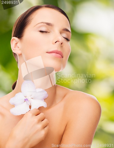 Image of relaxed woman with orhid flower