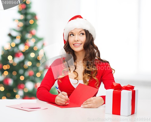 Image of smiling woman in santa helper hat with postcard