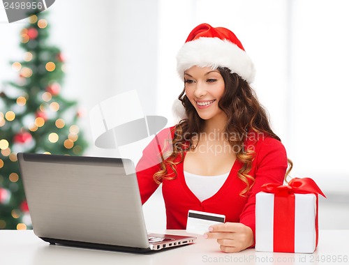 Image of woman with gift, laptop computer and credit card