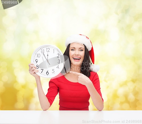 Image of woman in santa helper hat with clock showing 12