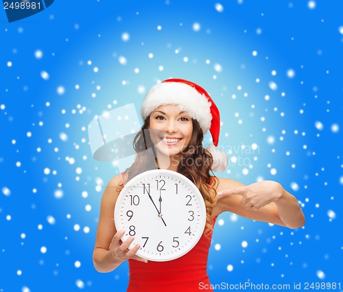 Image of woman in santa helper hat with clock showing 12