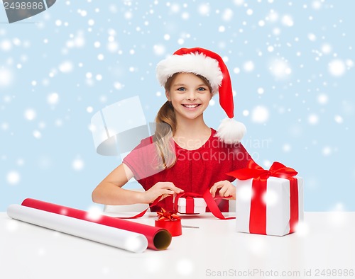 Image of smiling girl in santa helper hat with gift box